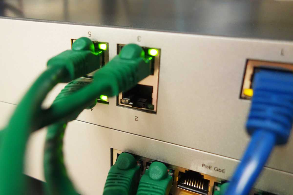 Green and blue ethernet cables plugged into a router