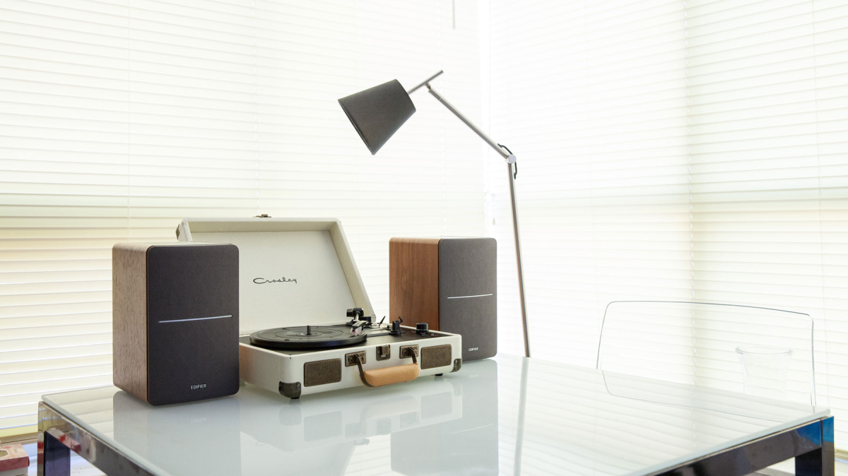 Edifier R1280T on a table next to a turntable and a lamp