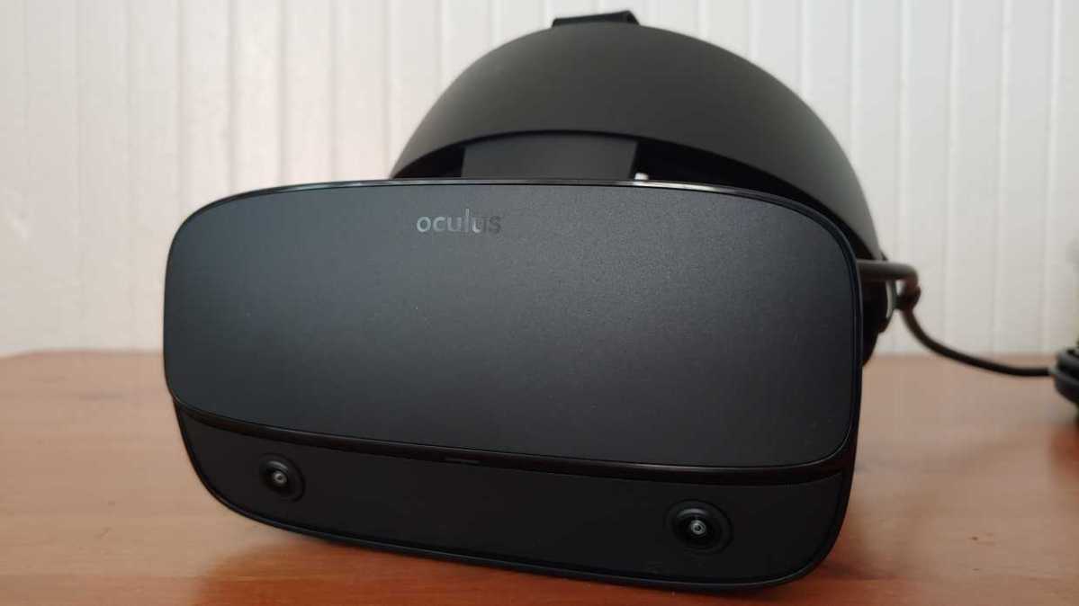oculus Rift S headset on a brown desk with a ridged white wall in the background