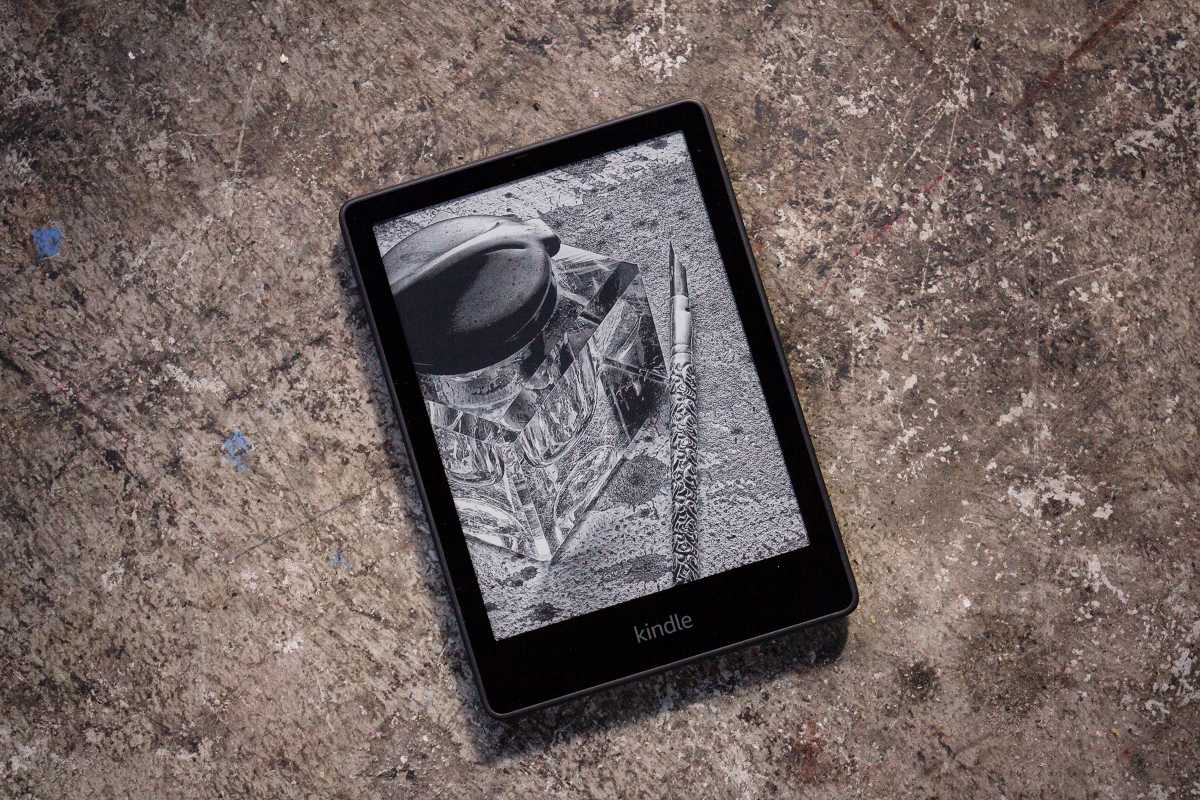 Kindle Paperwhite (Signature Edition) on a speckled gray concrete floor