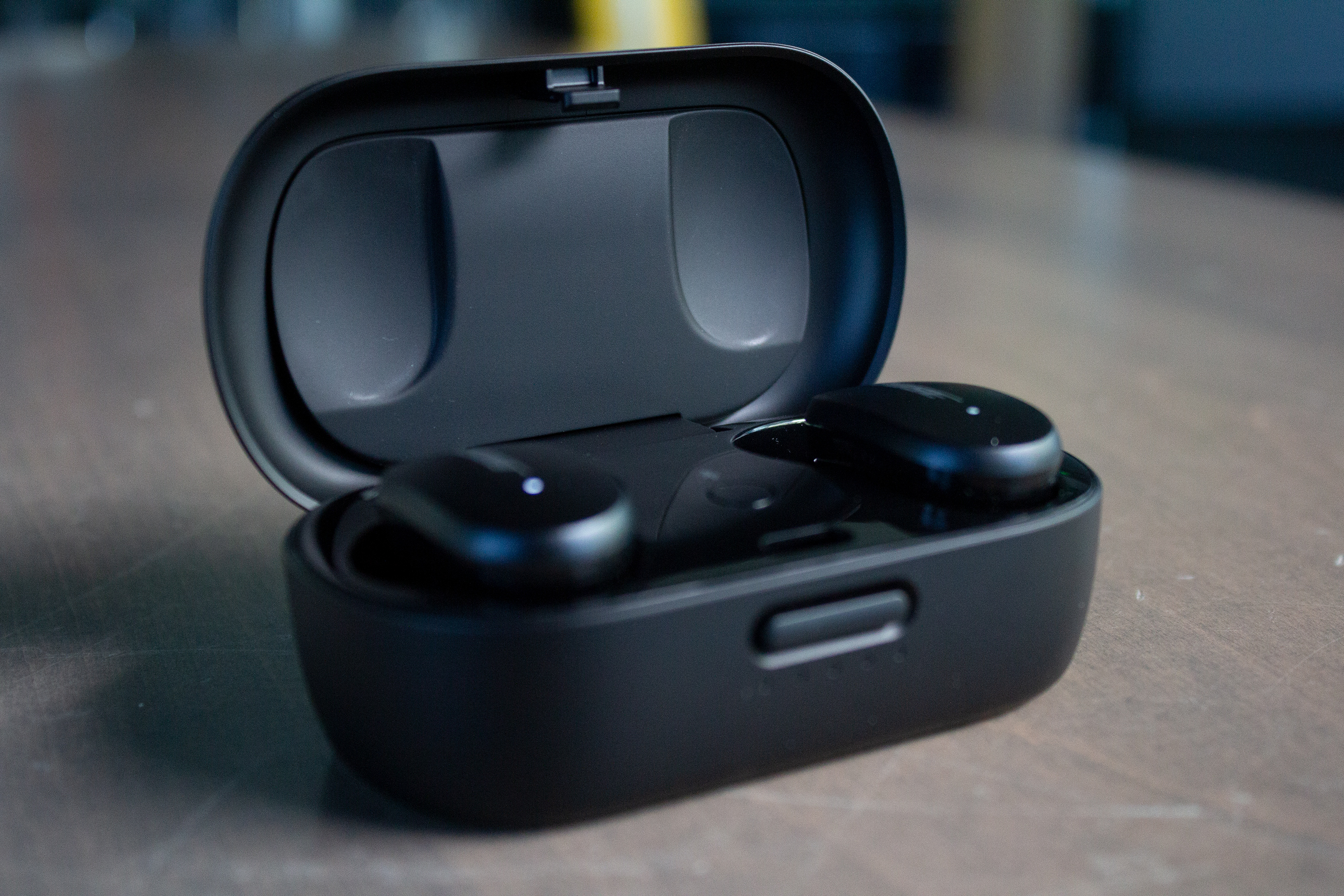 Bose QuietComfort Earbuds in their charging case on a table