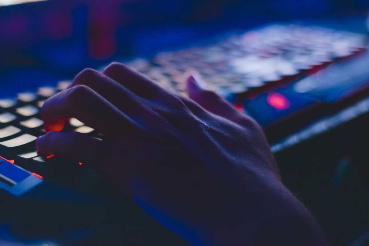 Person typing on a desktop PC keyboard