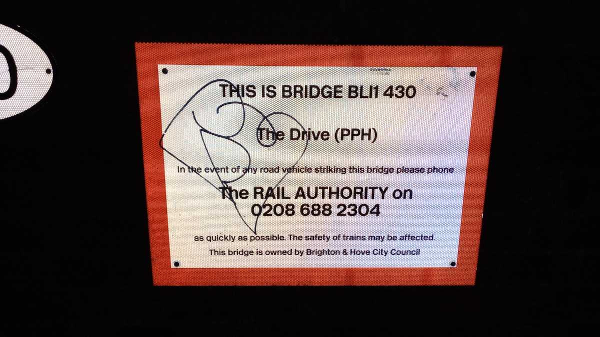 A sign on a railway bridge