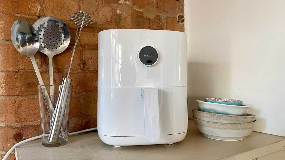 White air fryer next to some kitchen utensils and bowls