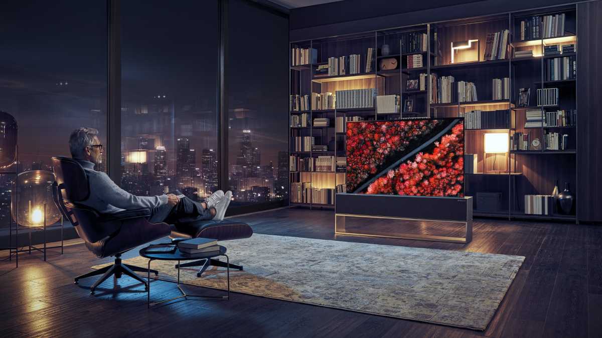 A man watching the LG OLED R TV
