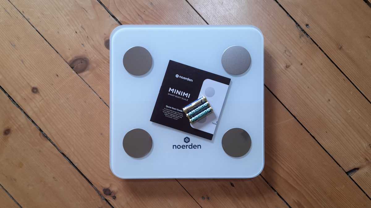 Noerden Minimi smart scale with batteries included, standing on a wooden floor