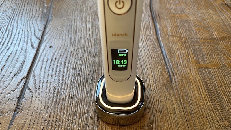 The Planck 01 electric toothbrush in its illuminated charging base