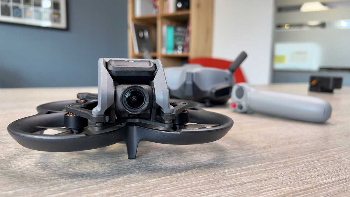 DJI Avata drone on a desk with accessories in the background