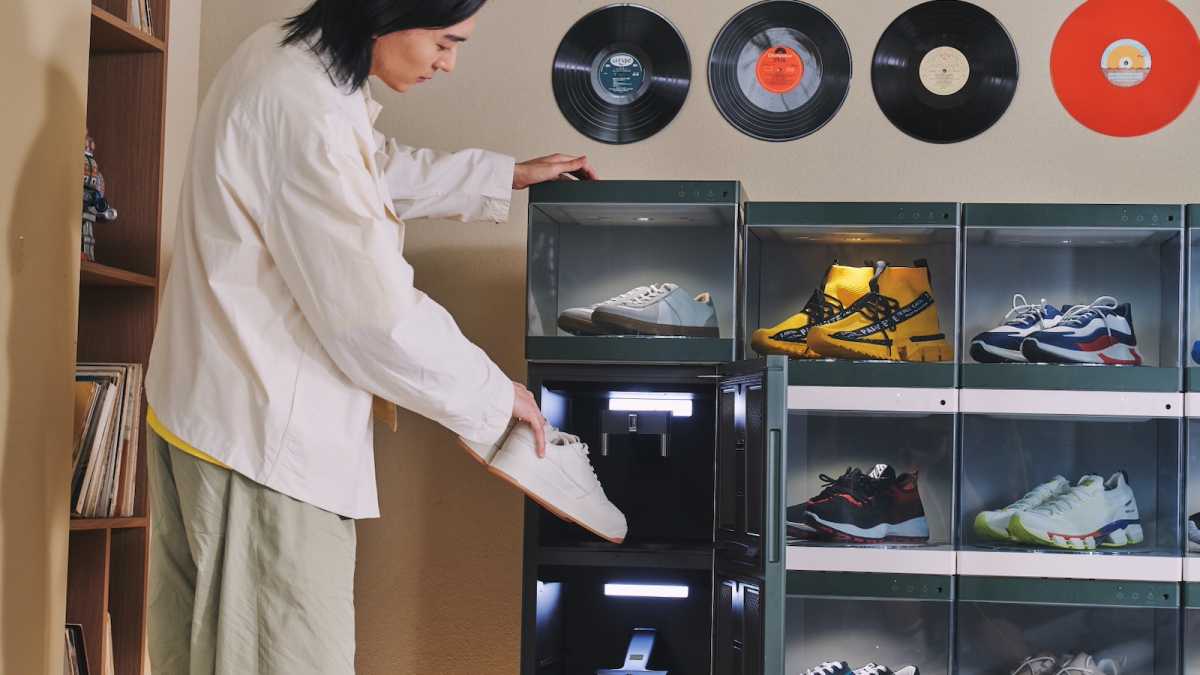 A man puts a pair of trainers into the LG ShoeCare