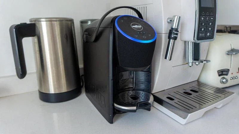 Lavazza Voicy pod coffee maker n a counter next to a kettle and other countertop appliances