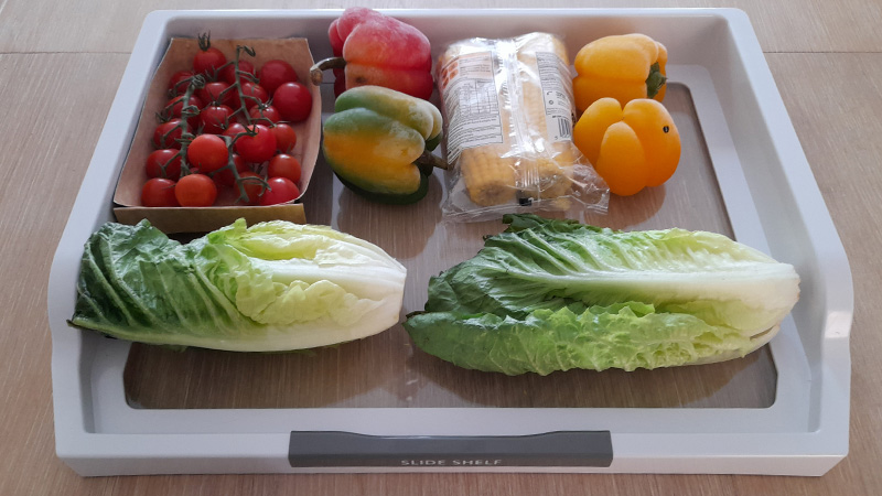 Slide shelf with a punnet of tomatoes, two lettuces, four peppers and sweetcorn to show capacity