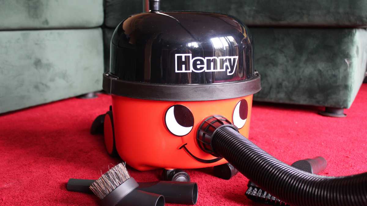Henry vacuum with attachments on a red carpet