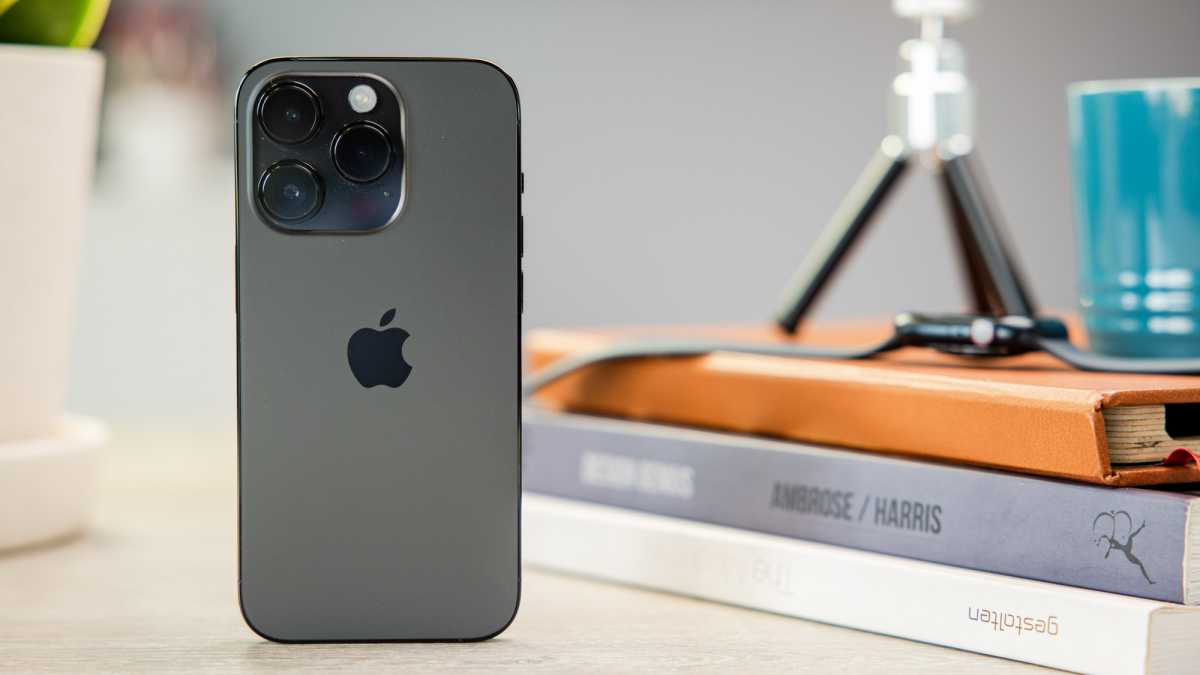 iPhone 14 Pro met boeken op de achtergrond