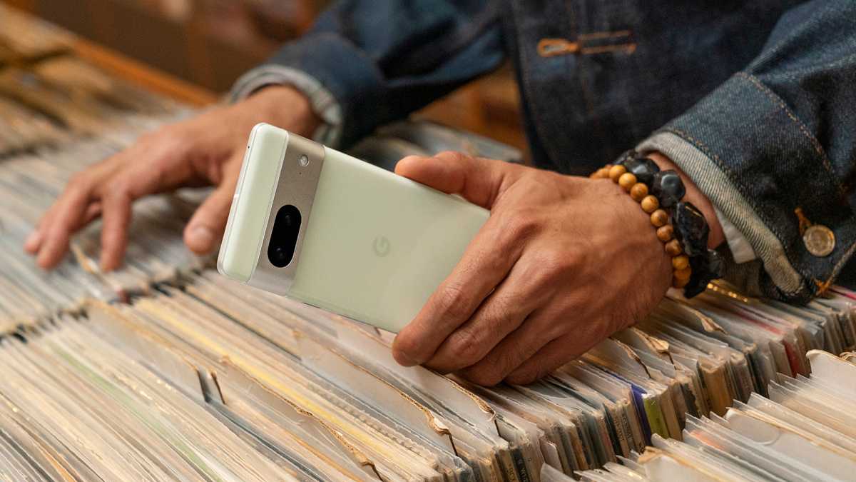 A green Pixel 7 in someone's hand browsing records