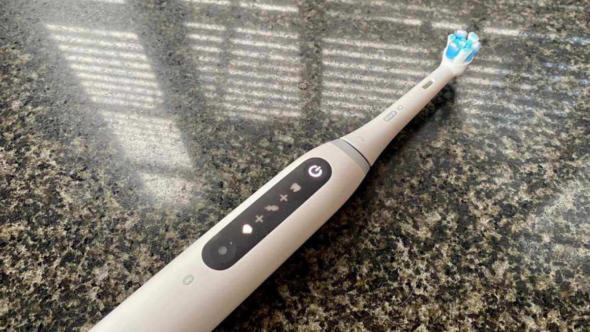 White Oral-B iO brush showing brushing model symbols