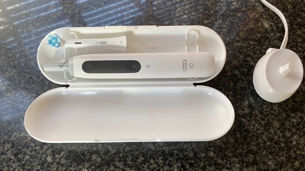 iO5 brush in travel case, with charging stand nearby