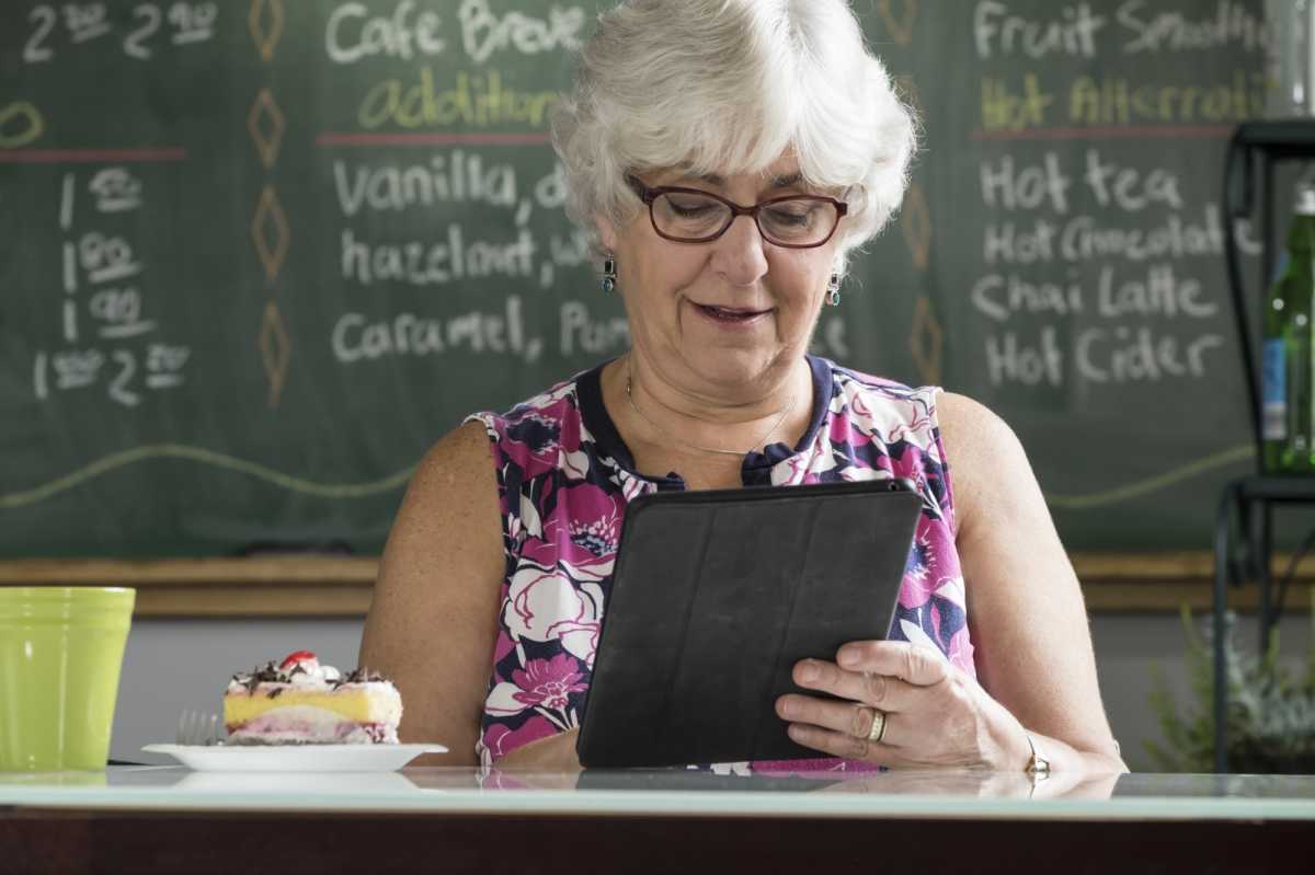 Seniorin im Café mit iPad