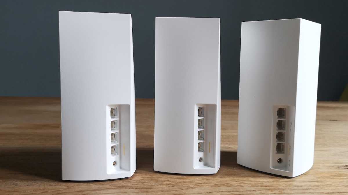 Three Linksys Atlas 6 units set up on a table, their Ethernet ports facing forwards
