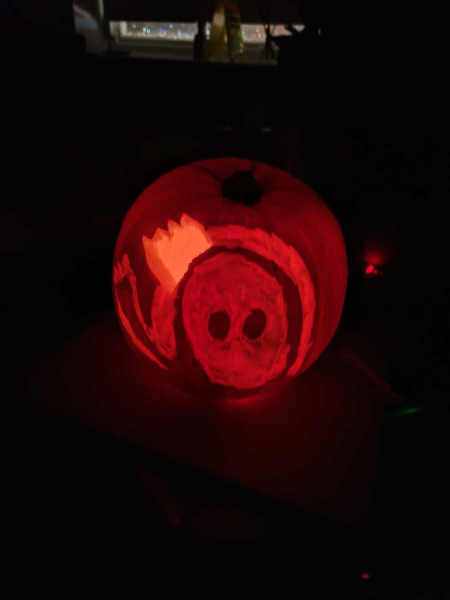 Jack-O-Lantern of a Fall Guys character in a dark room