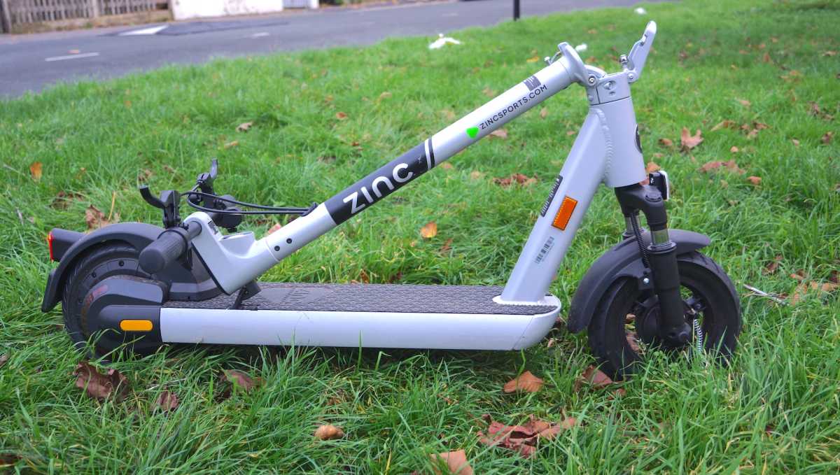 Side-on shot of the Zinc Velocity Plus Electric Scooter folded on grass
