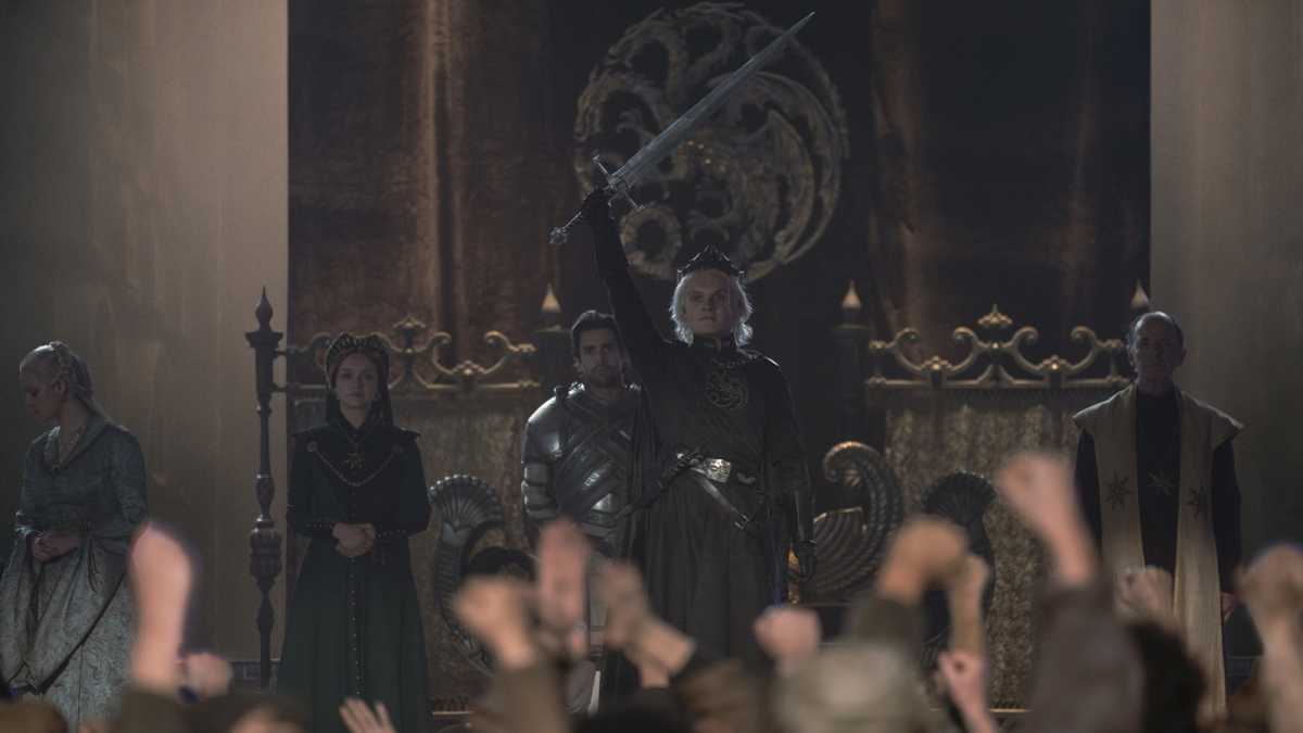 King Aegon Targaryen II holding a sword as he is crowned King of the Seven Kingdoms