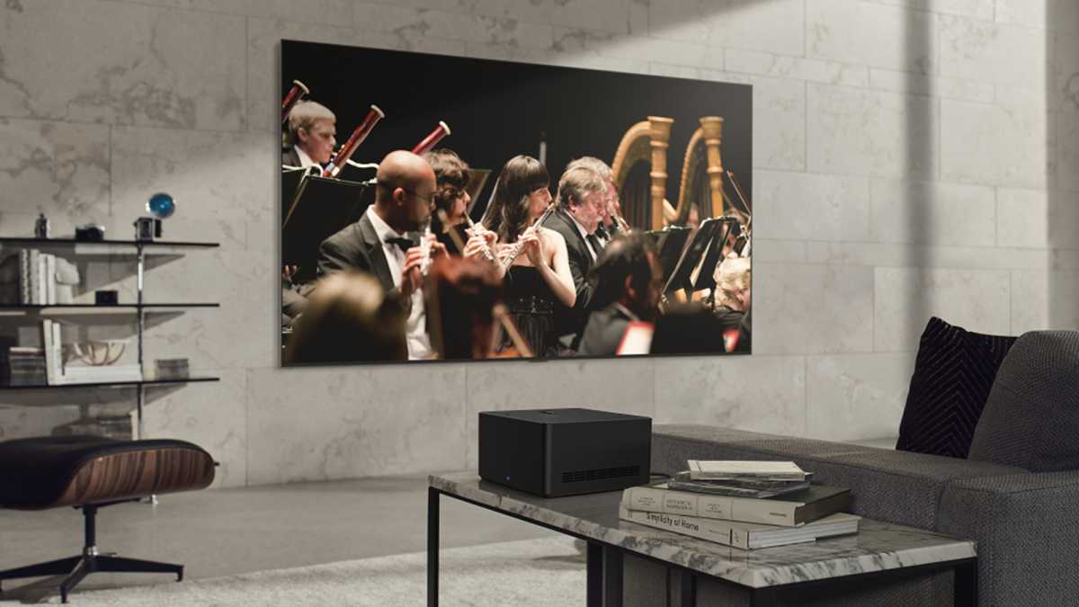Wireless LG Signature OLED M TV on living room wall playing a video of an orchestra