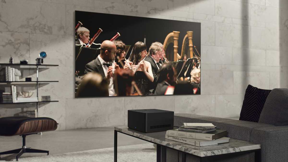 Wireless LG Signature OLED M TV on living room wall playing a video of an orchestra