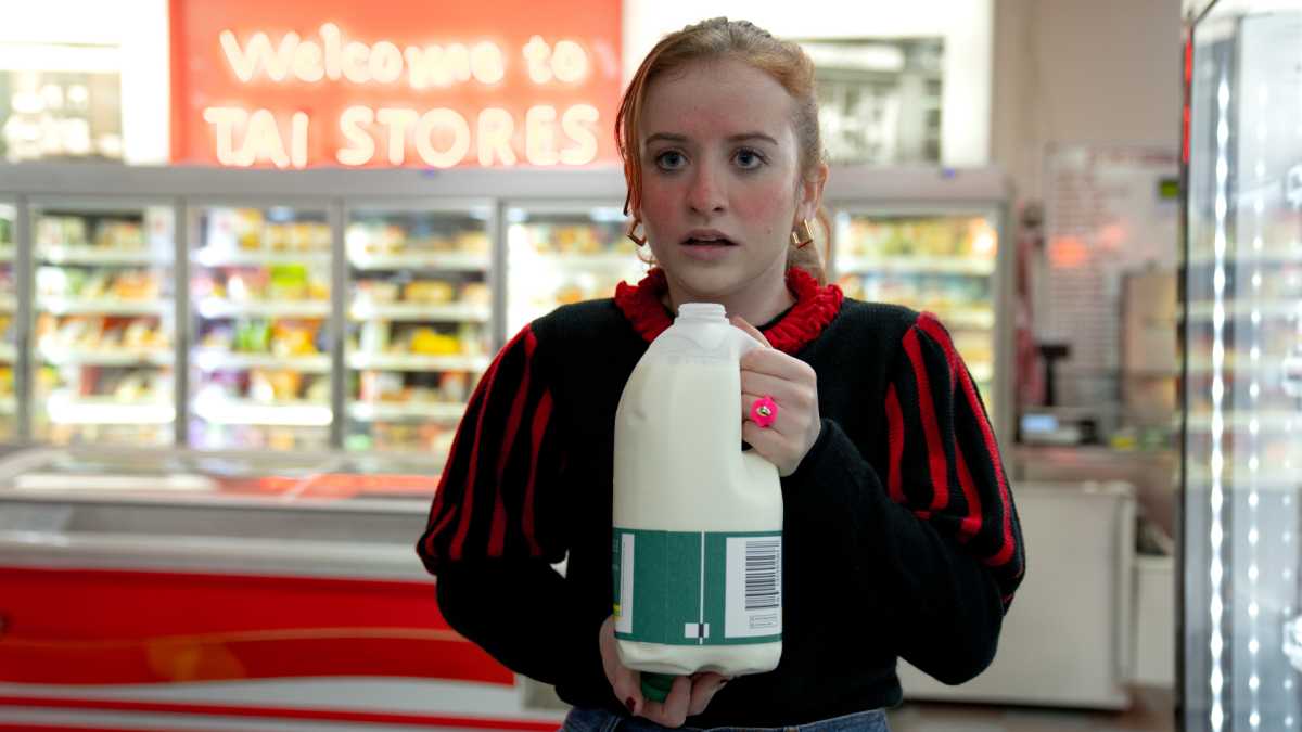 Jen in the Disney+ series Extraordinary holding a bottle of milk