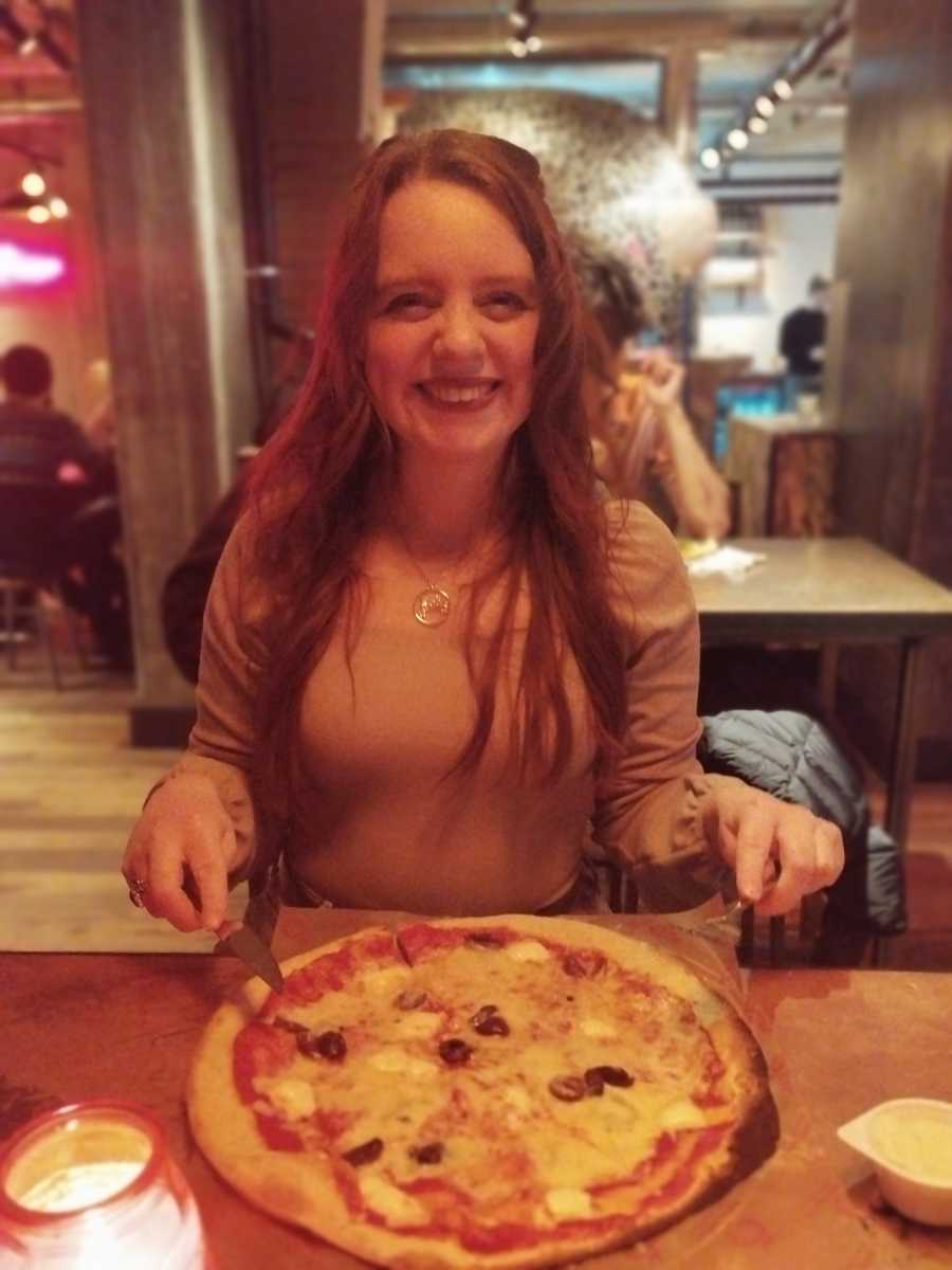 Woman eating a pizza in a restaurant 