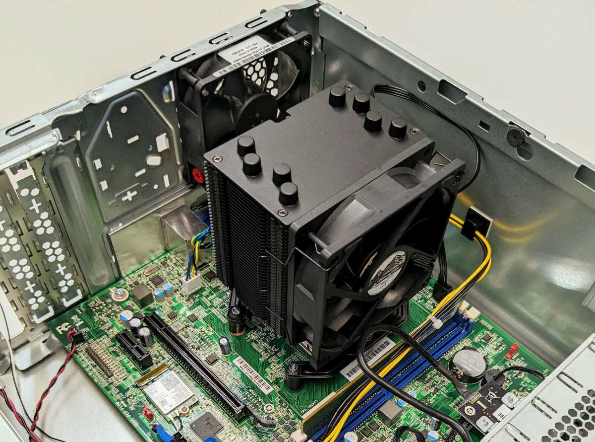 Der eingebaute Standardkühler (links) bedeckte nur etwa die Hälfte der CPU-Oberfläche, der neue Heatpipe- Kühler rechts im Bild wird auf zwei Haltestegen befestigt.
