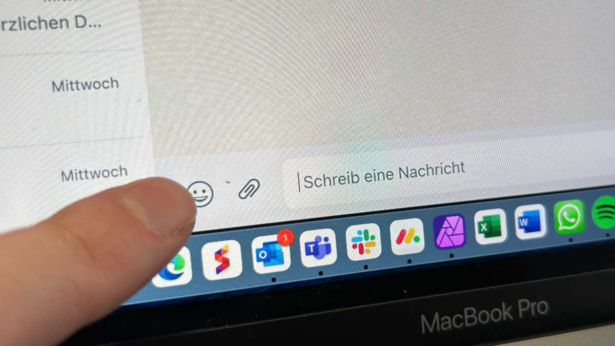 Finger zeigt auf das Emoji-Symbol in Whatsapp auf einem Macbook Pro