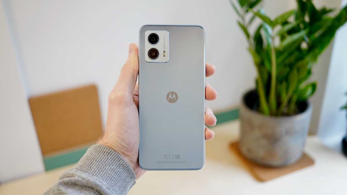 Motorola Moto G53 5G in hand with plant behind