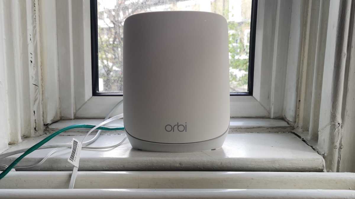 Netgear Orbi RBR760 router set up in a living room, connected to a modem