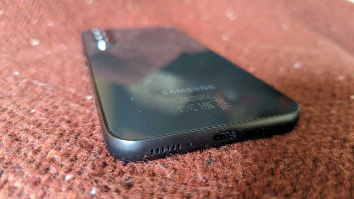 El Samsung Galaxy A54 boca abajo sobre un tejido rojo