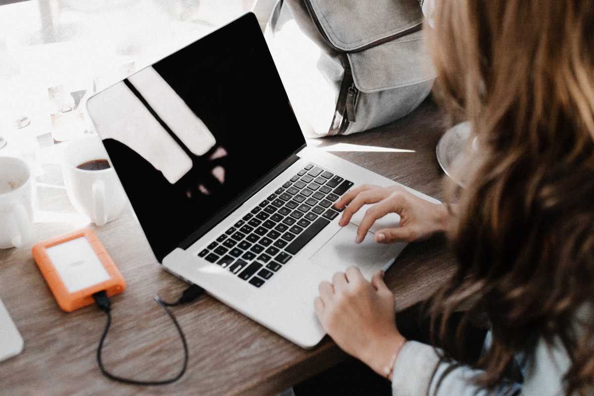 Woman using a computer with a backup drive attached