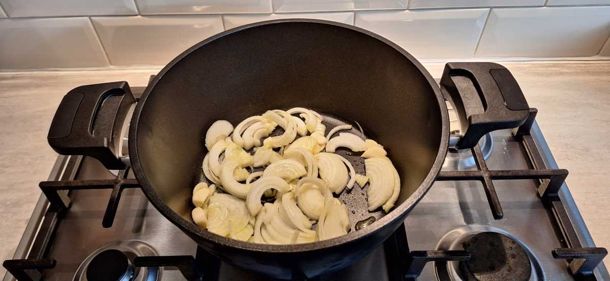 A view of onions inside the Remoska Tria pot on a gas hob.