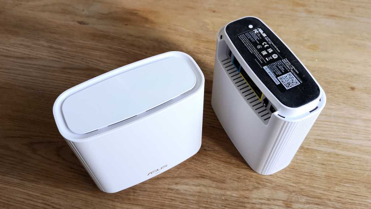 Two white Asus ZenWiFi XT9 units viewed from above, one is inverted, showing off the rubberised base