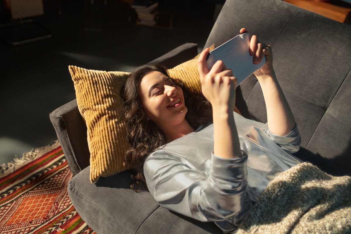 Person ligger i soffa och spelar på en Logitech G Cloud