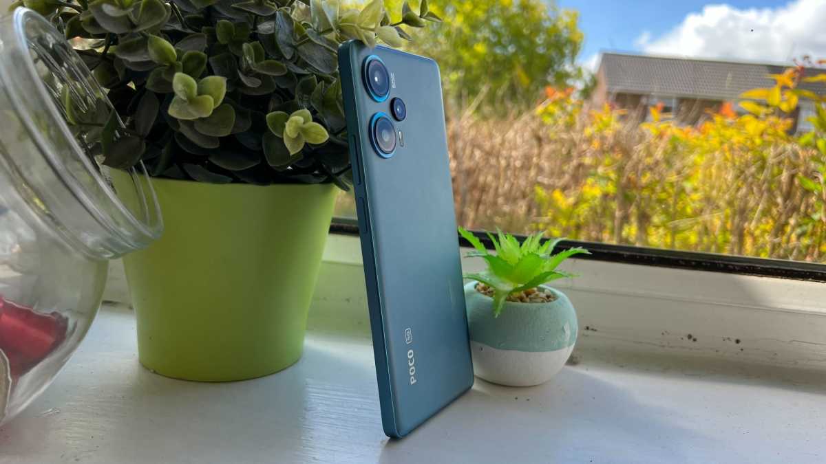 Poco F5 leaning on a plant