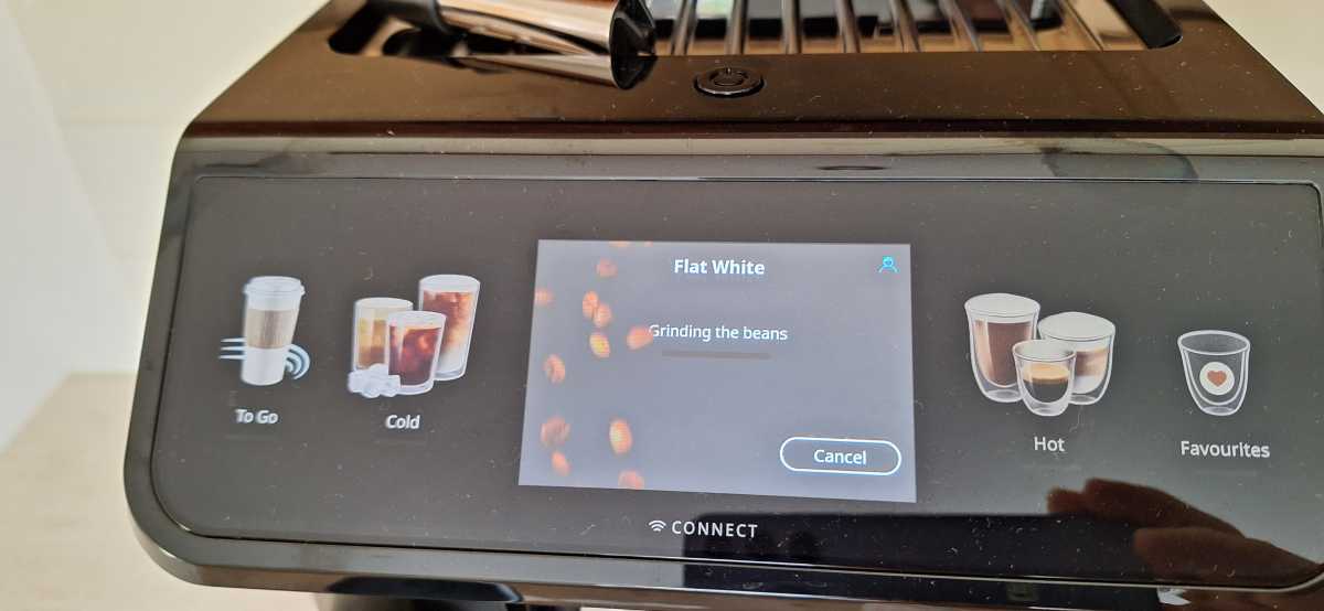 A view of the DeLonghi Eletta Explore touchscreen showing bean grinding