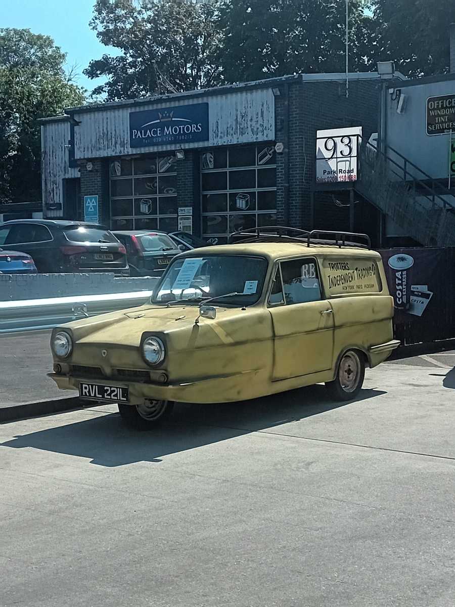 Yellow three-wheeled car from Only Fools and Horses at garage in London