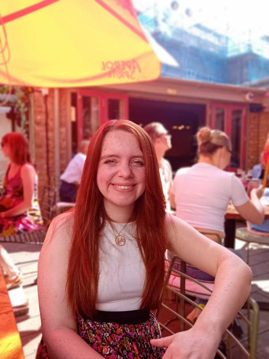 Red haired woman sat in beer garden