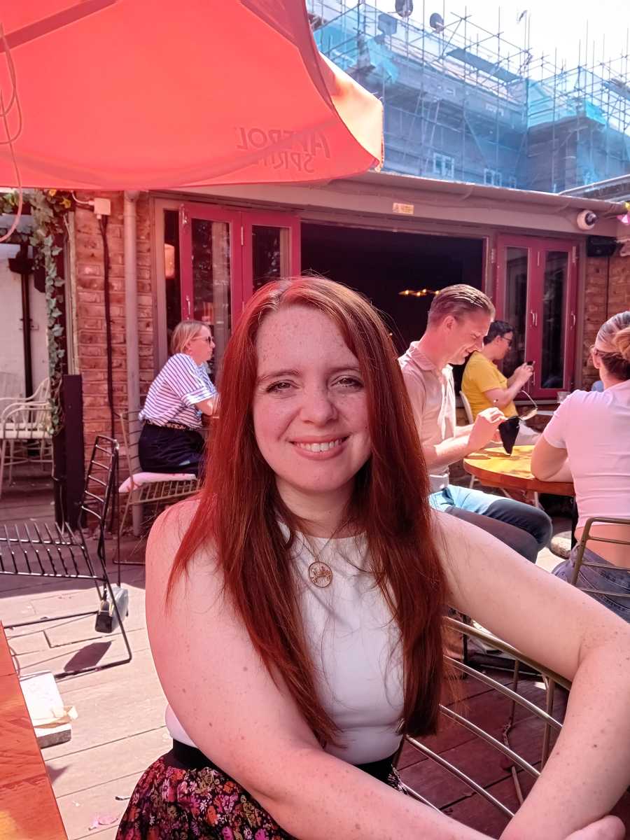Red-haired woman sat in beer garden