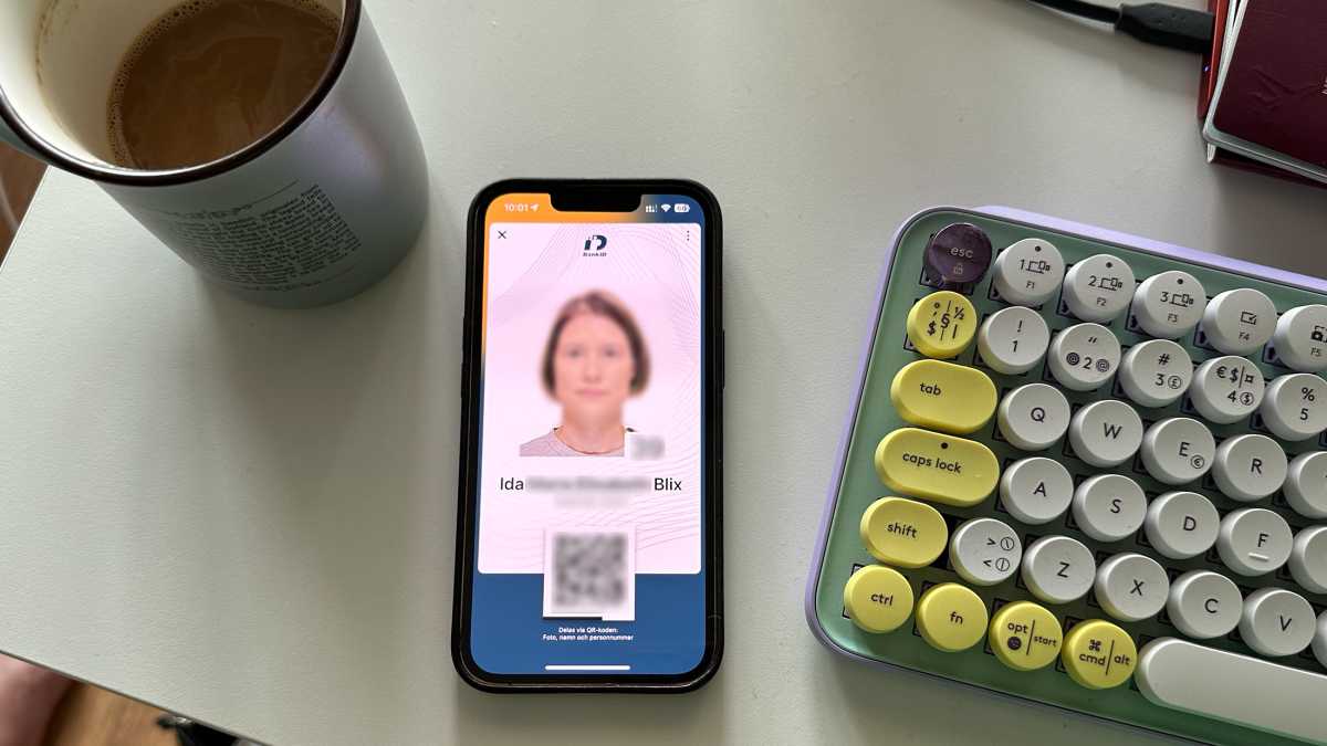 Mobiltelefon på skrivbord med digitalt-id i bank-id-appen öppet på skärmen.