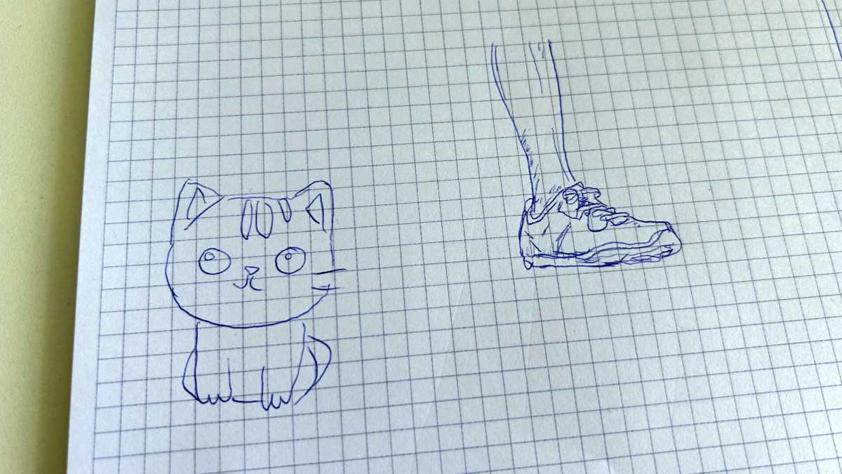Katze und Bein mit Schuh mit Kugelschreiber auf kariertem Papier