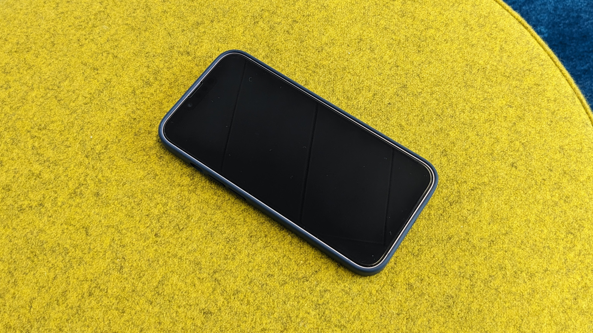 iPhone 14 in einer blauen Silikonhülle mit sichtbarem Alu-Rahmen