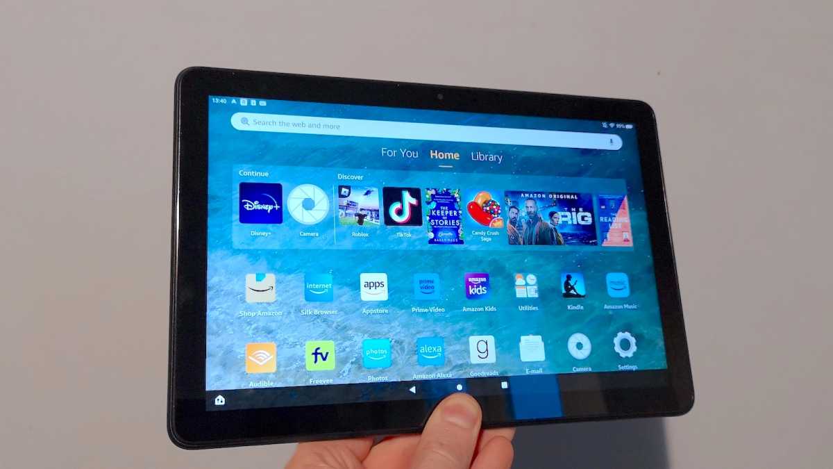 A close-up of the Amazon Fire HD 10 (2023) held in landscape mode, with the Home screen visible