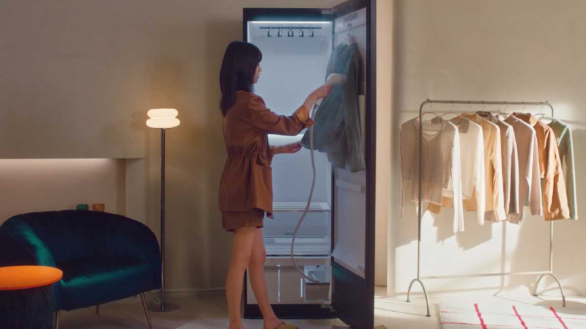 Woman smoking clothes inside door of LG Styler