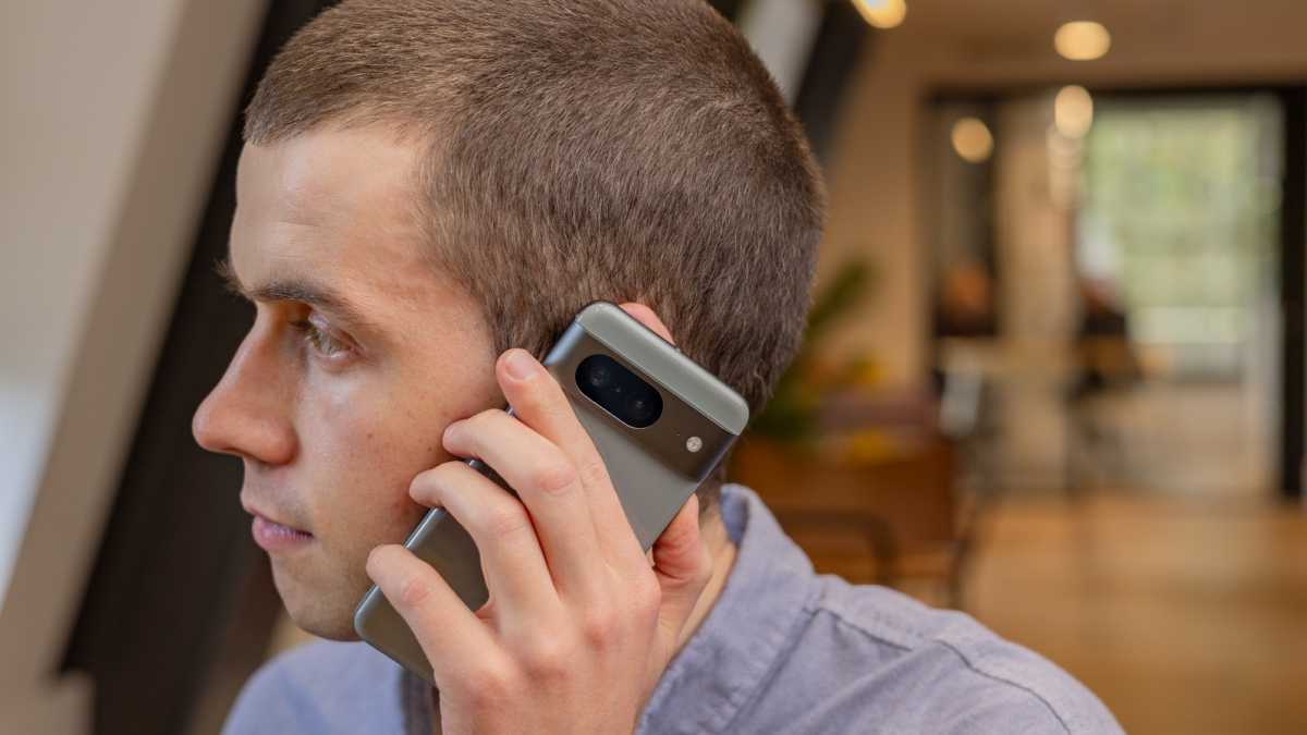 A man holding up a smartphone to his ear