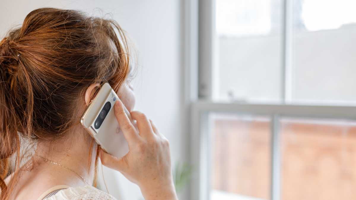 A woman holding the Google Pixel 8 Pro to her ear